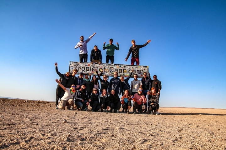 Group of people posing with a Tropic of Capricorn sign.