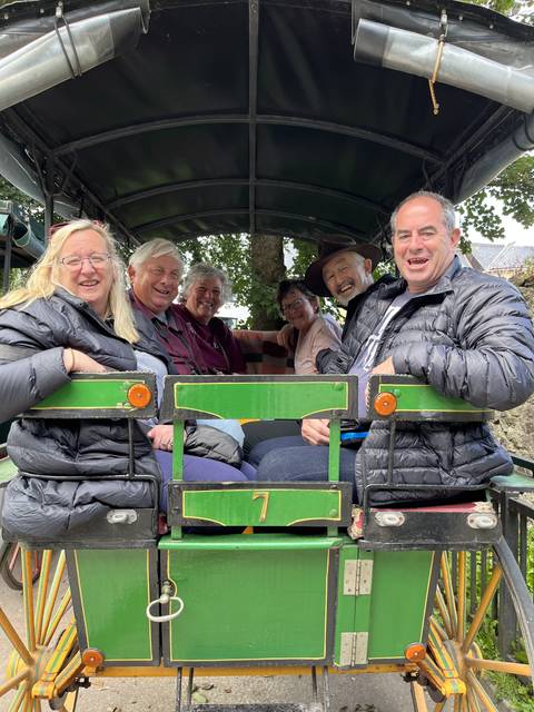 Group of people smiling in a horse-drawn carriage