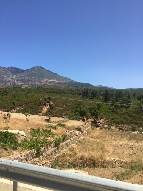       Mountainous landscape under a blue sky.
  