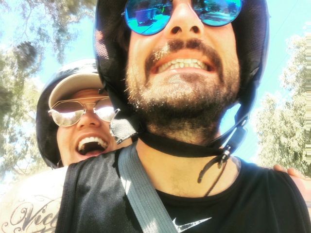       Close-up selfie of two people wearing helmets.
  