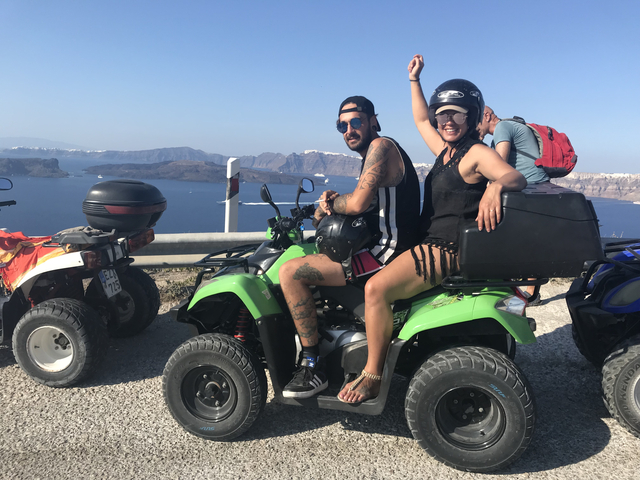       Two people on an ATV overlooking a scenic coastal view.
  