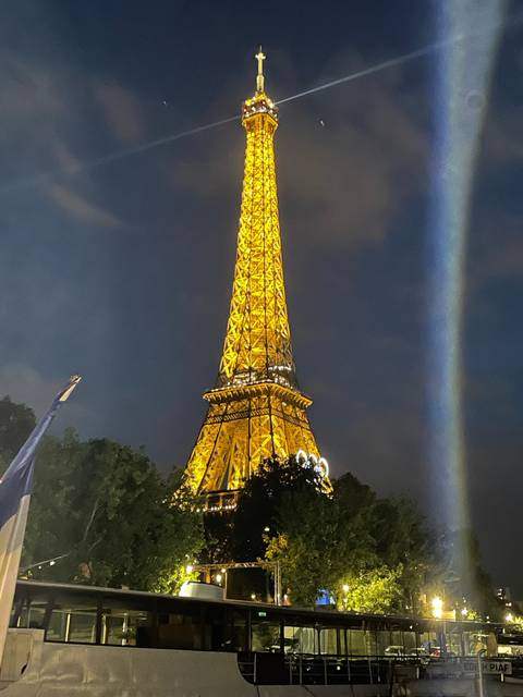 Illuminated Eiffel Tower at night against a dark sky.