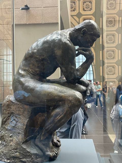       Bronze sculpture of a thoughtful seated figure.
  