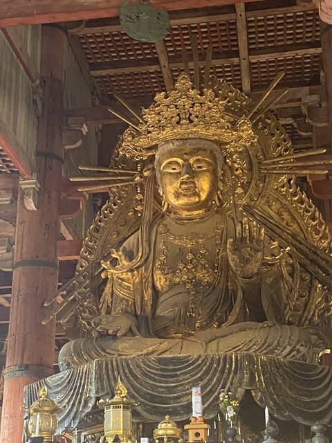 Golden statue of a seated deity inside a temple.