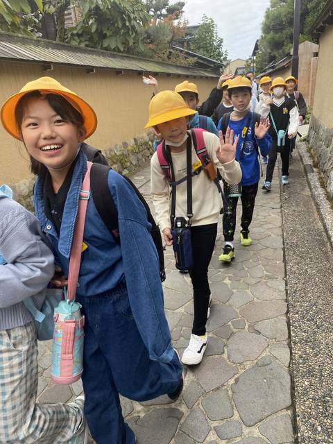 Group of children in uniforms walking down a path.