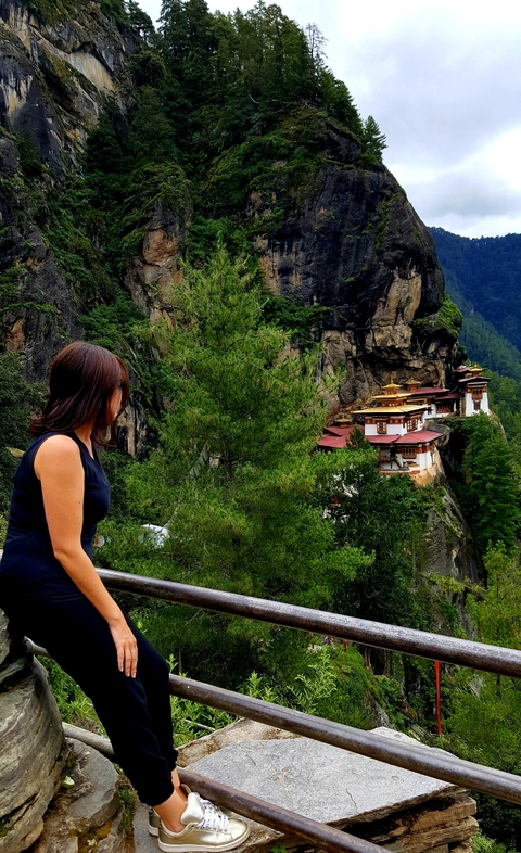 Person looking at Tiger's Nest Monastery on a cliffside.
