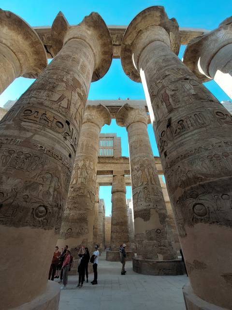 Massive columns with hieroglyphics in an ancient Egyptian temple.