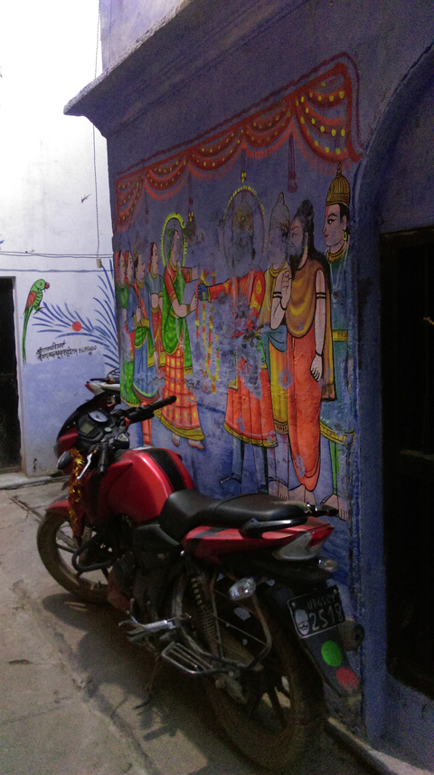 Street mural with a parked motorcycle in the foreground.