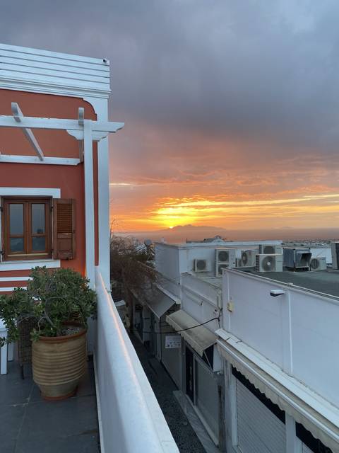 Sunset view over a cityscape with traditional Greek architecture.