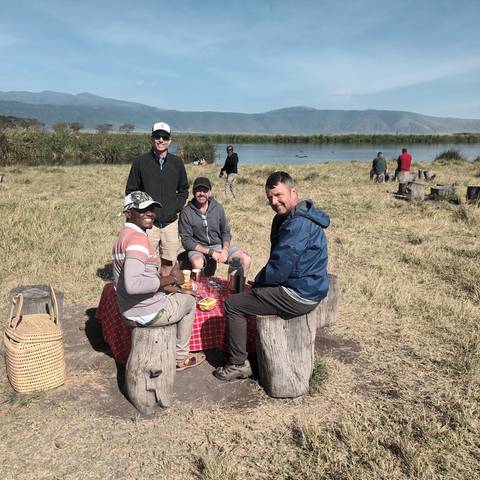 Group of people having a picnic by a lake.