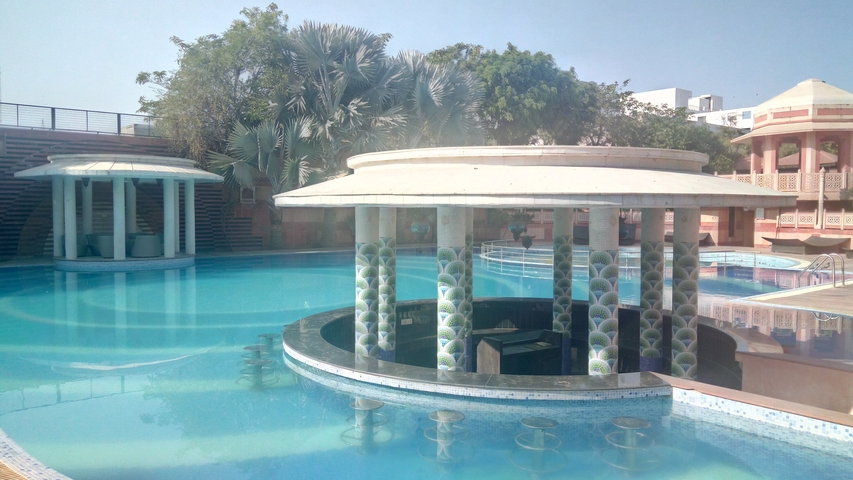 Outdoor swimming pool with bar seating.
