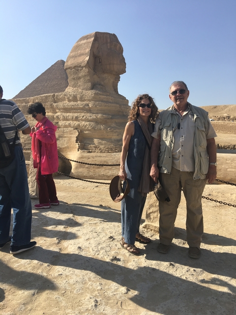       Group of tourists posing in front of the Sphinx.
  