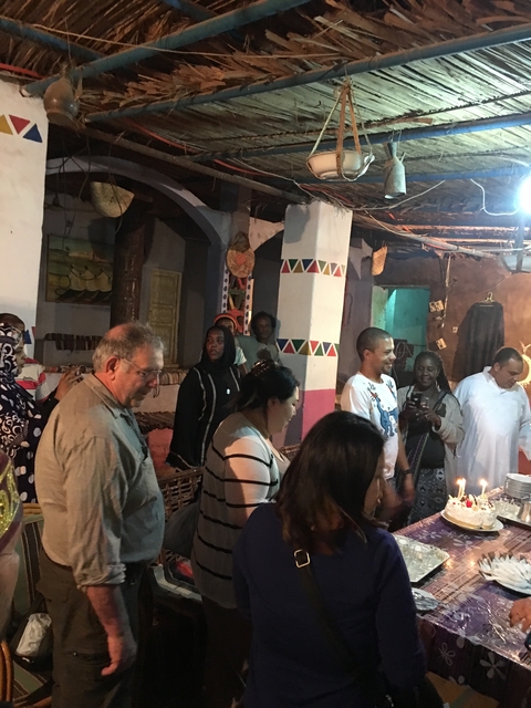       Group of people in a dimly lit room with decorative elements.
  