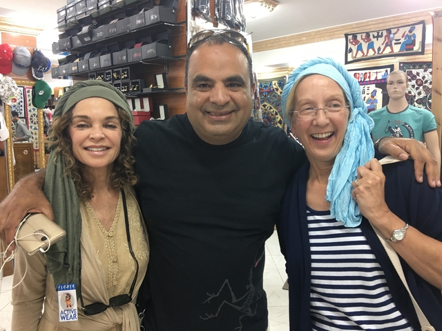 Three people posing together in a shop.