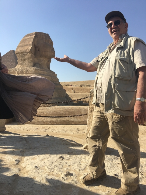 Partial view of the Sphinx with two people in front.