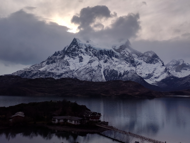       Mountain range with snowy peaks reflecting on a lake.
  