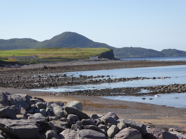       Coastal scene with rocky shores and hills.
  