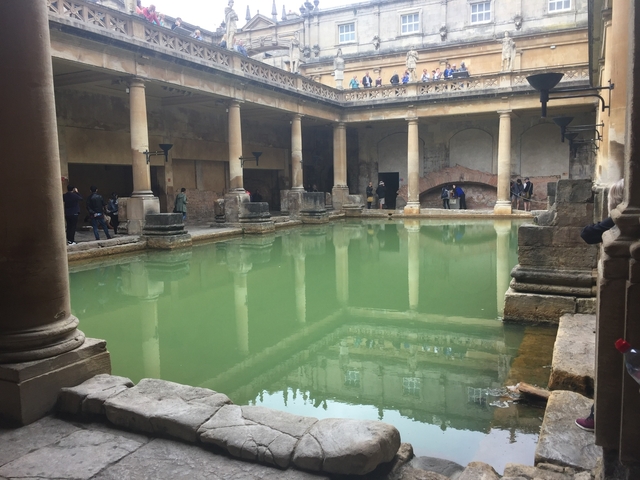       A historic Roman bath with a pool in the center.
  
