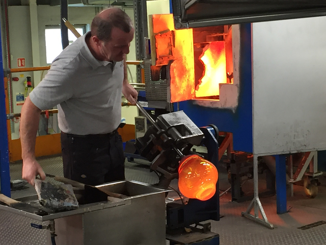       Glassblower working with molten glass.
  