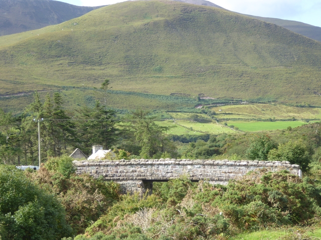       Stone bridge against a backdrop of green hills.
  