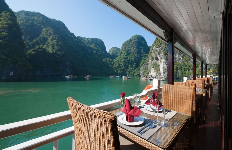       Dining setup on a cruise ship with a view of karst mountains
  