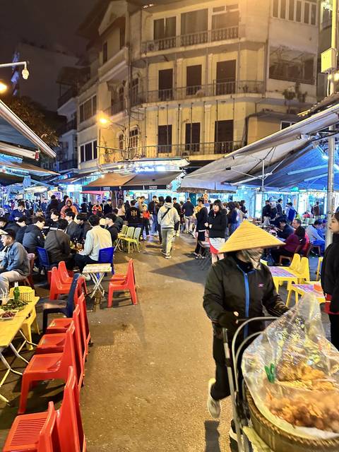 Crowded street market bustling with people at night.