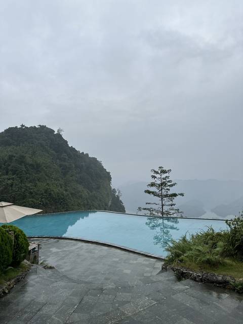 Infinity pool with view of foggy mountains.