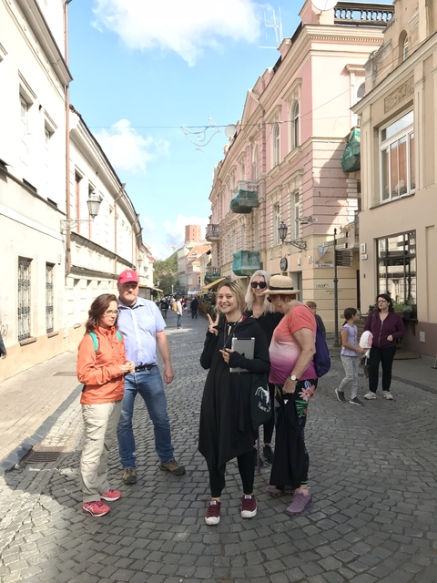 Group of people posing on a cobblestone street.