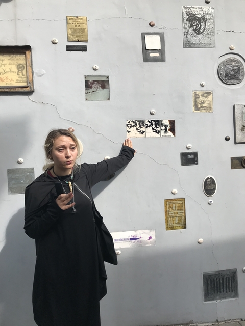 Guide pointing at something on a historical wall.