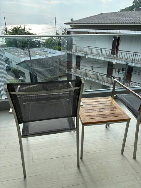 Balcony view showing chairs and part of a building.