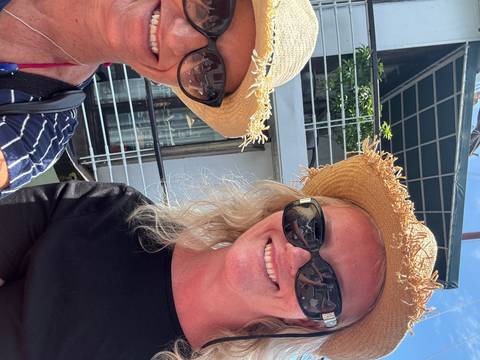       Two women taking a selfie outdoors wearing sunhats.
  