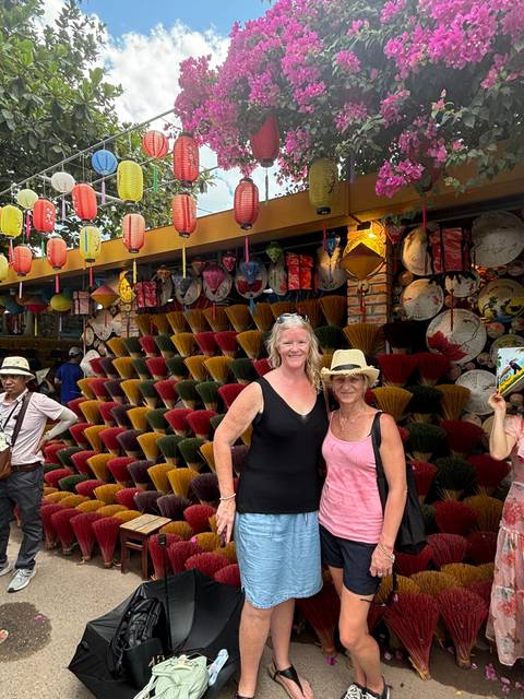 Two women posing in front of colorful lanterns.