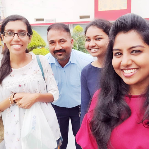Group selfie of smiling people outdoors.