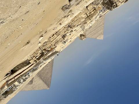       Side view of the Sphinx and pyramids in the desert.
  