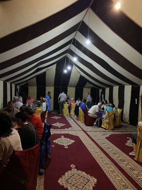 People dining inside a tent with traditional decor.