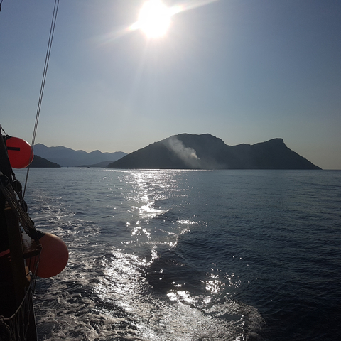       Sunset view over the sea with silhouette of mountainous islands.
  