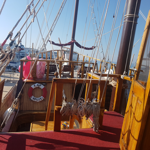 Deck of a ship in a harbor with nautical equipment.