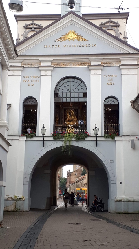 Facade of a church with people on a balcony.