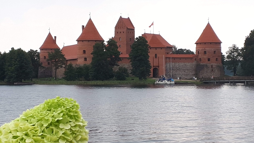 Trakai Castle surrounded by a lake with boats.