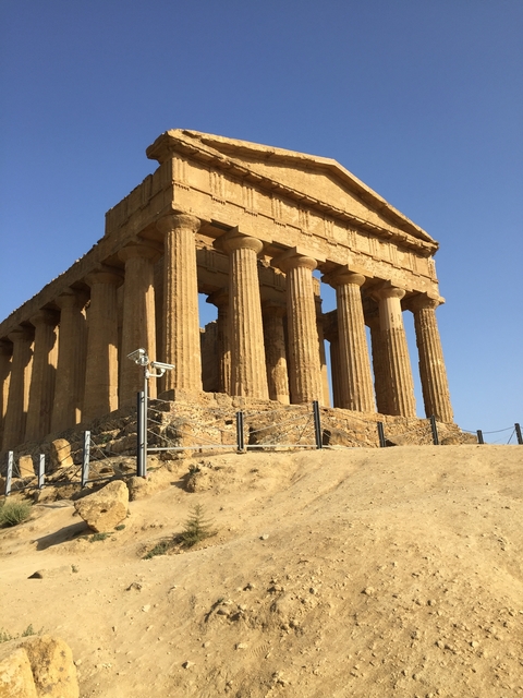       Ancient Greek-style temple under a blue sky.
  
