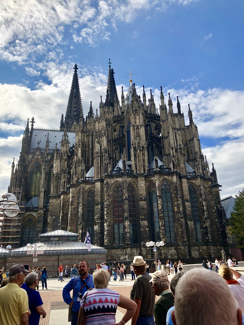 Gothic cathedral with intricate architecture under a cloudy sky.