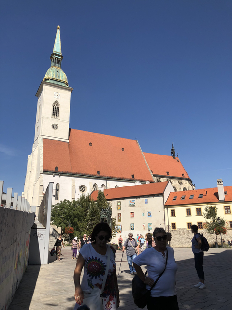 Large church building with orange rooftops against a clear sky.