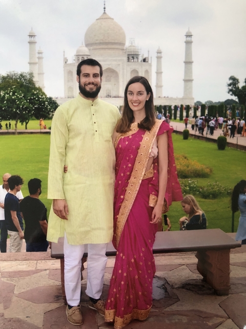 Couple posing in traditional attire in a garden.