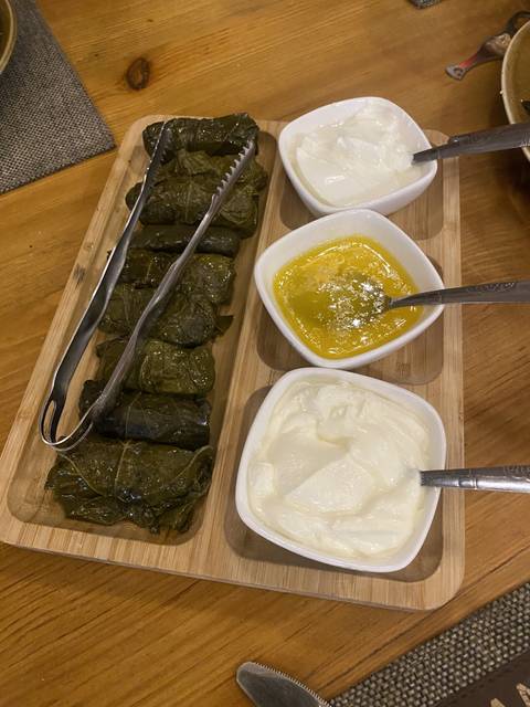       Serving of stuffed grape leaves with yogurt.
  
