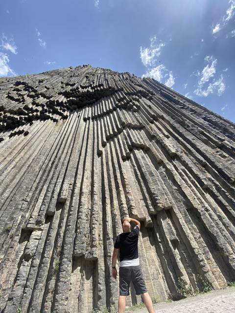       A person standing in front of rock formations.
  