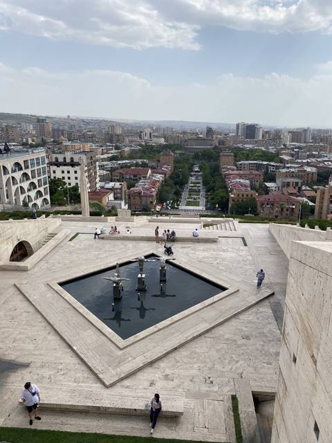       A cityscape with buildings and a pool of water.
  