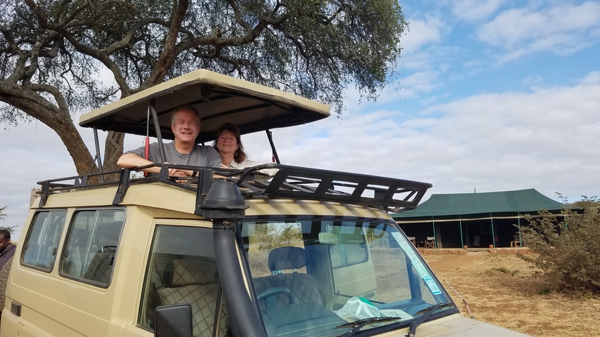 Couple in a safari vehicle in the savannah.