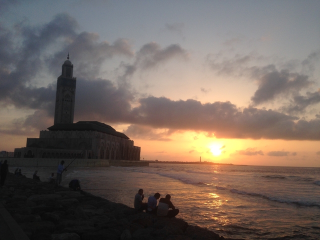       Sunset view over the ocean with a mosque in the background.
  