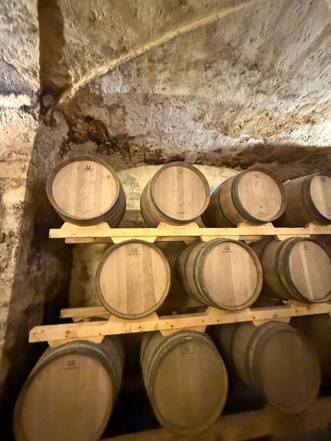       Wine barrels stacked inside a cellar.
  