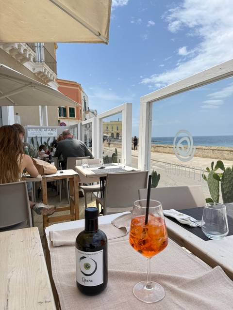       Outdoor dining area with a glass of aperitif and a bottle.
  